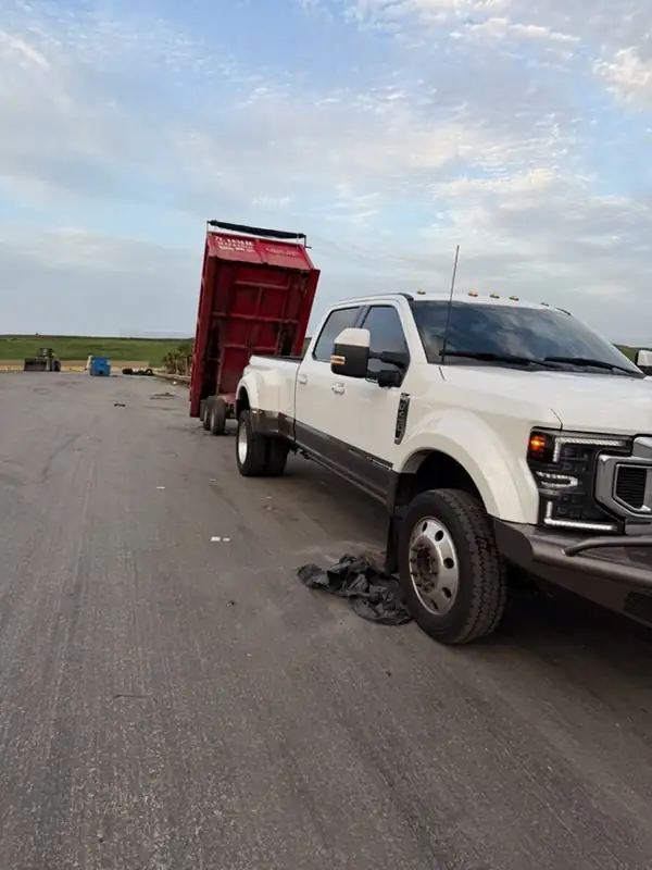 R. Leslie Hauling tilting the dump trailer to unload debris
